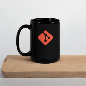 May include: A black ceramic mug with a white handle and a red and black GitHub logo on the front.