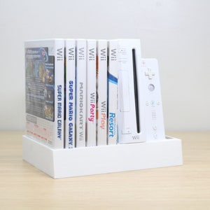 Puede incluir: Consola Wii blanca y seis estuches de juegos, incluyendo Super Mario Galaxy, Mario Kart Wii, Wii Party, Wii Play y Wii Resort. La consola y los juegos est&aacute;n en un soporte blanco.