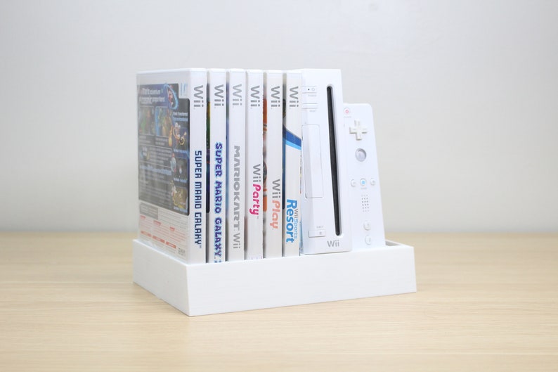 Puede incluir: Consola Wii blanca y seis estuches de juegos, incluyendo Super Mario Galaxy, Mario Kart Wii, Wii Party, Wii Play y Wii Resort. La consola y los juegos est&aacute;n en un soporte blanco.