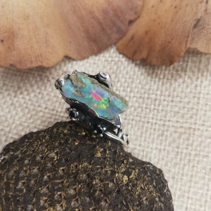 925 Sterling Silver ring with a fairly big rough beautiful opal stone in an authentic setting with two little black diamonds that complete its look nicely. A one-of-a-kind item that is very unique. It's all handmade by me, Frantsi.