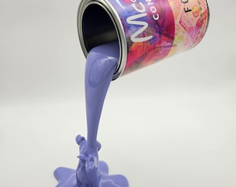May include: A sculpture of a paint can pouring out lavender-colored paint. The can has a colorful label with text that reads "MCB CONDEN" and "FORTU SOL". The paint forms a star-shaped puddle.