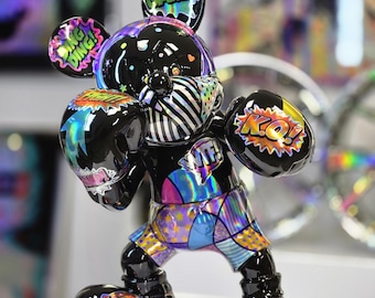 May include: A glossy black figurine of a cartoon mouse in a boxing stance, wearing holographic patterned shorts and gloves. The figure features colorful comic-style text graphics including DAMN, DING DING, FIGHT, KO, WTF, and HOOK printed on its surface.