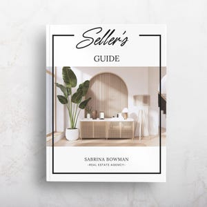 May include: A white book cover titled Seller's GUIDE by SABRINA BOWMAN -REAL ESTATE AGENCY-. The cover features a central photograph of a room with a wooden slatted arched wall, a cane-front sideboard, a tall potted plant, and a tripod floor lamp.