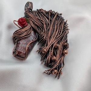 Colgante con cabeza de caballo de ágata musgosa roja envuelto en alambre de cobre con