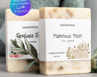 May include: Two rectangular bars of off-white soap wrapped in white paper labels. The labels feature the text Luxe Soap & Salve, Farmhouse Fresh, linen + gardenia, and 8 oz | 227 g, with floral illustrations. A blue circular badge reads Editable Canva Templates 7 Designs.