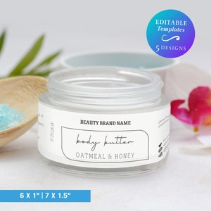 Op de afbeelding: Een glazen pot met een wit etiket waarop "BEAUTY BRAND NAME body butter OATMEAL & HONEY" staat. De pot staat op een wit oppervlak.