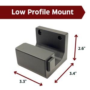 May include: A gray plastic low profile mount with dimensions of 3.3 inches by 3.4 inches by 2.6 inches.