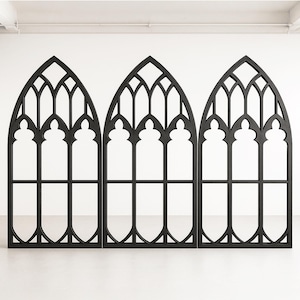 Op de afbeelding: Drie zwarte decoratieve gebogen raampanelen. Elk paneel heeft een gotisch ontwerp met ingewikkelde traceringen en een spitsboog. De panelen zijn vrijstaand en geschikt voor interieurdecoratie.