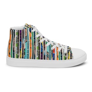 May include: White high-top canvas sneakers with a colourful comic book print. The print features a variety of comic book panels with superheroes and villains.