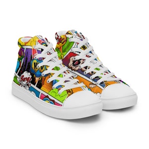 Puede incluir: Un par de zapatillas blancas de lona de caña alta con un estampado de cómic colorido. El estampado presenta palabras como "¡Bang!" y "¡Wow!" e imágenes de superhéroes y explosiones.