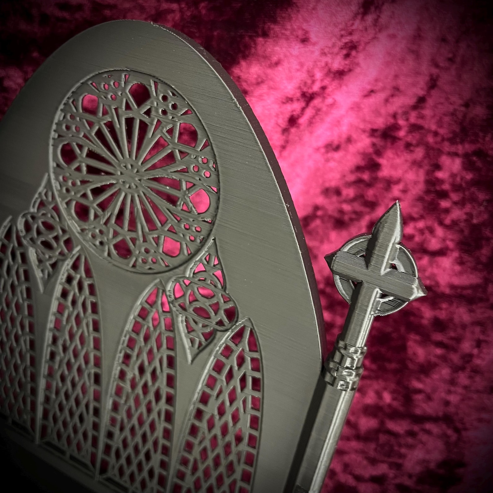 Close up of gothic-style miniature accessory tray with cathedral-like spires and rose window details, set against red velvet fabric