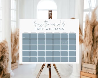 Op de afbeelding: Een blauwe en witte kalender met de tekst "Guess the arrival of Baby Williams" bovenaan. De kalender is voor de maand mei en heeft een uitgerekende datum die op de 10e is gemarkeerd.