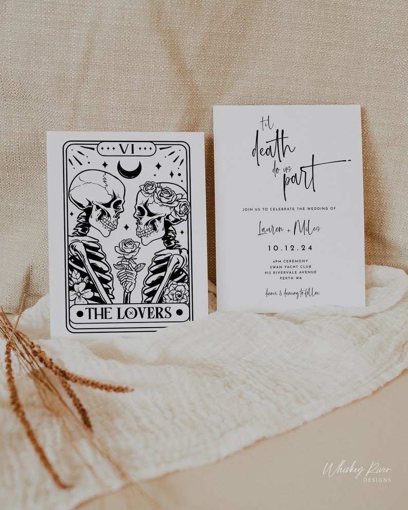 May include: Two white wedding invitation cards. One card features a black and white tarot card design with skeletons and the text "THE LOVERS". The other card has the text "Til death do us part" and wedding details.