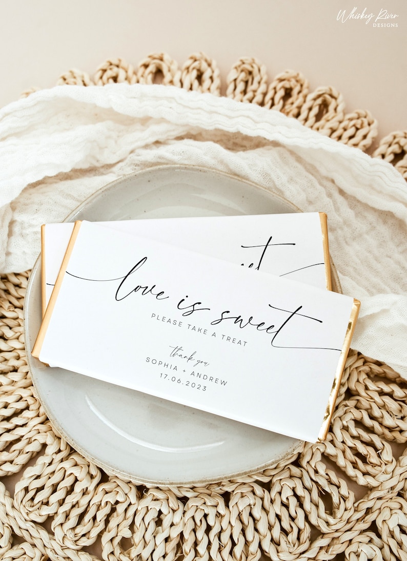 May include: White chocolate bar wrapper with gold foil accents. The wrapper has black calligraphy that reads "love is sweet" and "Please take a treat". Below the text is "Thank you" and the names "Sophia + Andrew" and the date "17.06.2023".