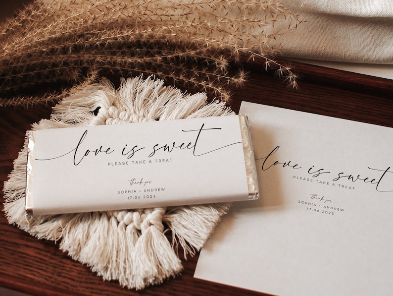 May include: White chocolate bar wrapper with the text "love is sweet please take a treat" and "thank you Sophia Andrew 17.06.2023".