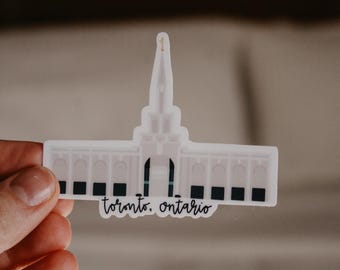 May include: White sticker of a church building with a tall spire and the text "Toronto, Ontario".