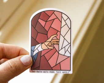 May include: A stained glass window sticker with a hand reaching out from the left side. The sticker is pink, red, and white. The text at the bottom reads "Thy faith hath made thee whole."