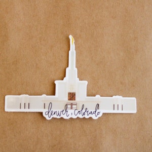Op de afbeelding: Witte sticker van de tempel van Denver, Colorado, met de tekst "Denver, Colorado" eronder.