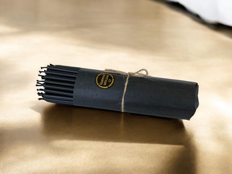 May include: A roll of black hair ties wrapped in black paper with a gold label that says "Handmade with Love".
