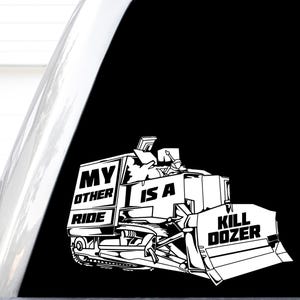 May include: A white vinyl decal featuring a graphic illustration of a bulldozer with the text "MY OTHER RIDE IS A KILL DOZER" printed on the side. The design is rendered in a bold, high-contrast style suitable for application on smooth surfaces.