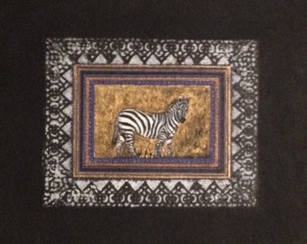 May include: A black and white zebra illustration framed in a gold and blue patterned frame on a black background.
