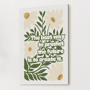 Puede incluir: Impresión en lienzo rectangular con un diseño floral. Presenta margaritas y hojas verdes, con el texto "The best way to predict the future is to create it" en verde.