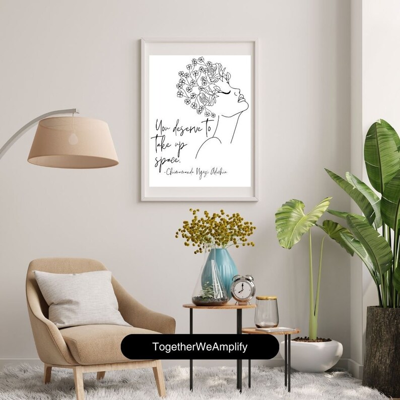 May include: Black and white line art print of a woman with flowers in her hair. The quote "You deserve to take up space." by Chimamanda Ngozi Adichie is printed below the image. The print is framed and hanging on a white wall.