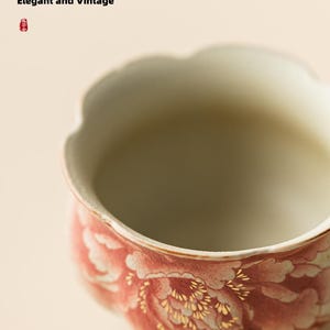 May include: A ceramic bowl with a scalloped rim, featuring a floral design in shades of red and white with gold accents. The text "Festive and Fashionable, Elegant and Vintage" is visible in the background.