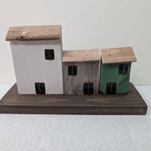 Three small, rustic, miniature folk art houses