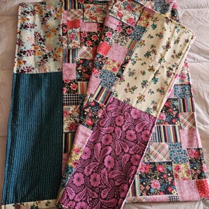 May include: Three patchwork fabric placemats in a variety of floral patterns, including pink, blue, green, and yellow. The placemats are made of cotton fabric and have a quilted texture.