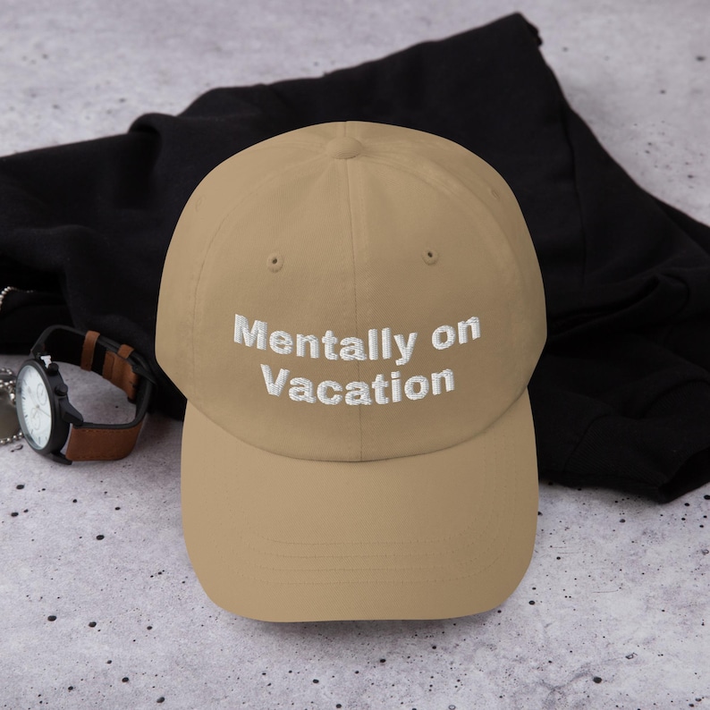 May include: A tan baseball cap with white embroidered text that reads "Mentally on Vacation".