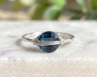Anillo solitario de plata de ley con topacio azul de Londres engastado en alambre.