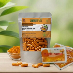 May include: A clear bag of turmeric capsules with the text "BEST 76 Turmeric Capsules". The bag is next to a small bowl of turmeric powder and several small packets of "Madunusa" honey. The capsules are orange and the powder is yellow.