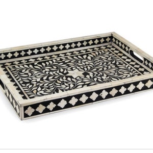 May include: Black and white rectangular tray with a floral design. The tray has a decorative border with a diamond pattern.