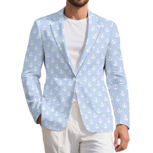 May include: Light blue blazer with a white anchor pattern. The blazer has a classic two-button closure and notched lapels. The model is wearing a white t-shirt and white pants. The blazer is a nautical-themed garment.