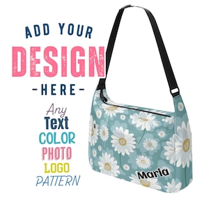 Może przedstawiać: Niebieska torebka na ramię z białym kwiatowym nadrukiem i regulowanym czarnym paskiem. Torebka ma zamek błyskawiczny i małą kieszeń z przodu. Tekst "Maria" jest nadrukowany na dole torebki.