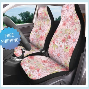 以下が含まれることがあります： ピンクとグリーンのフローラル柄のカーシートカバー2枚。カバーは背面と側面がブラック。カバーの前面はピンクの背景に、ピンク、グリーン、ホワイトのフローラル柄が施されています。