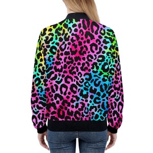 May include: A vibrant bomber jacket featuring a colorful leopard print design. The jacket showcases a black collar, cuffs, and hem, with a bold pattern of black spots against a rainbow gradient of pink, blue, green, and yellow.