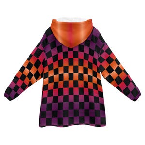 May include: A black and white checkered hooded blanket with a gradient of orange, red, and purple. The blanket has a large hood and long sleeves.