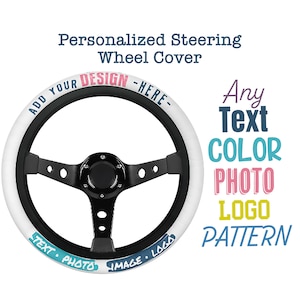 May include: White steering wheel cover with black spokes and a black center. The cover has the text "Add Your Design Here" in blue and pink lettering. The text "Text Photo Image Logo" is also on the cover in blue and pink lettering.