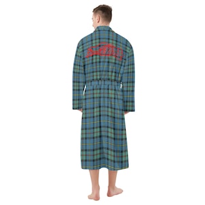 Könnte beinhalten: Blau-grüner und schwarzer karierter Bademantel mit passendem Gürtel. Der Bademantel hat lange Ärmel und das Wort "SCOTLAND" in roter Schrift auf dem Rücken. Der Bademantel ist knielang und aus weichem Material.