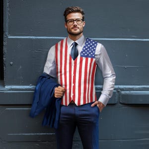 K&ouml;nnte beinhalten: Eine patriotische Weste mit dem Design der amerikanischen Flagge, mit roten und wei&szlig;en Streifen und einem blauen Sternenfeld. Die Weste wird &uuml;ber einem wei&szlig;en Hemd getragen, kombiniert mit einer marineblauen Krawatte und Hose. Eine marineblaue Jacke wird in der linken Hand gehalten.