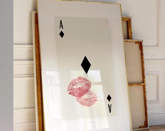 May include: A rectangular wall art print featuring the Ace of Diamonds playing card design. The card is off-white with black diamond symbols and the letter A in the corners. Two pink lipstick kiss marks are printed over the center diamond.