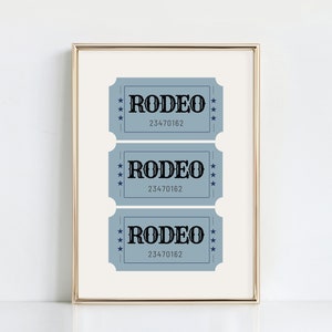 Puede incluir: Tres boletos azules con la palabra "RODEO" impresa en negro y el n&uacute;mero "23470162" impreso debajo. Los boletos est&aacute;n enmarcados en un marco dorado.
