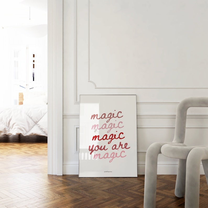 May include: A framed print with the text "magic magic magic you are magic" in shades of pink and red on a white background.