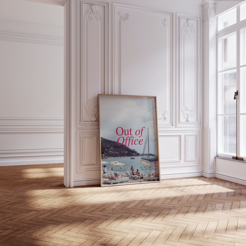 May include: A framed poster with a photo of a beach scene and the text "Out of Office" in pink letters.