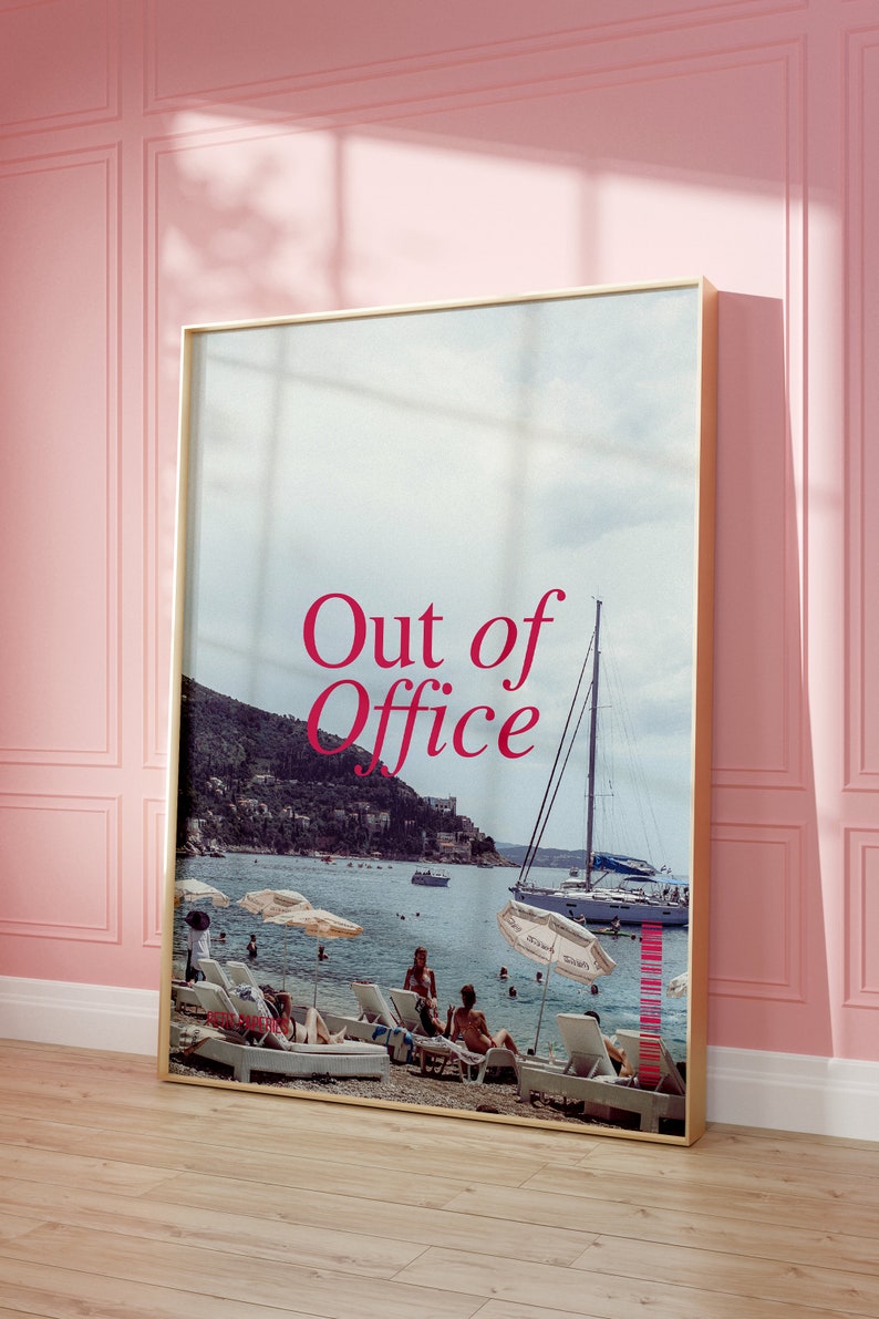 May include: A framed print with a photo of a beach scene with people relaxing on lounge chairs. The text "Out of Office" is printed in red on the print.