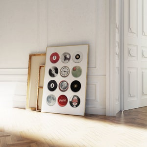 May include: A framed print with a white background and 12 round images. The images include a red billiard ball with the number 7, a clock face, a can of soda, a Coca-Cola can, a moon, and a woman wearing a red hat.