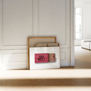 May include: A framed print of a red and white striped matchbox with the text "Ciao Bella" and a row of matches inside.