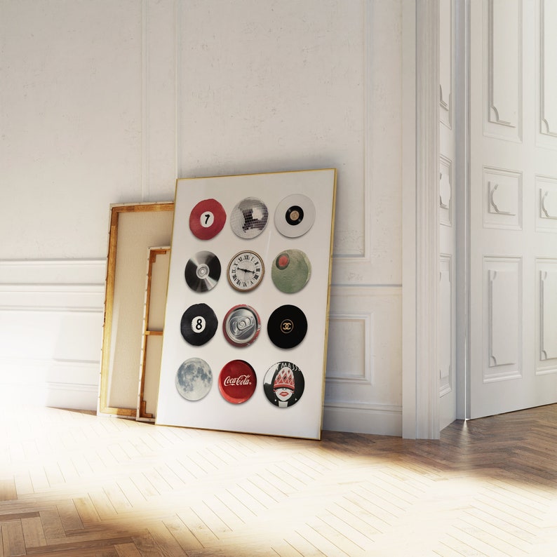 May include: A framed print with a white background and 12 circular images. The images include a red billiard ball with the number 7, a clock face, a can of soda, a Coca-Cola logo, a Chanel logo, and a woman's face.